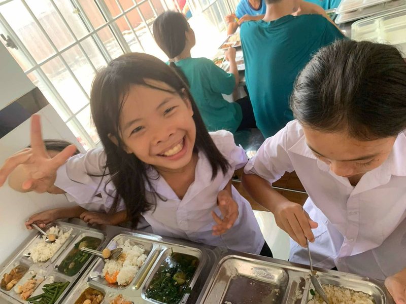 A smiling girl at a meal with other children