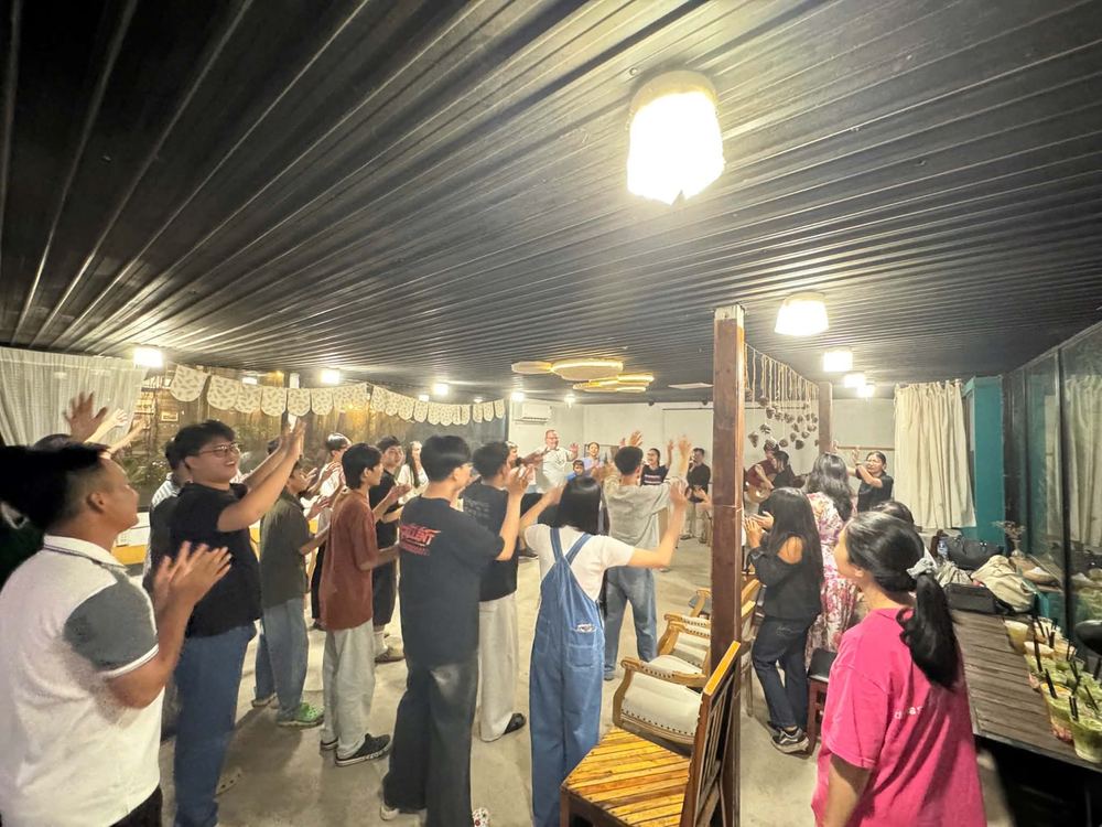 Young adults standing in worship at the coffee shop church