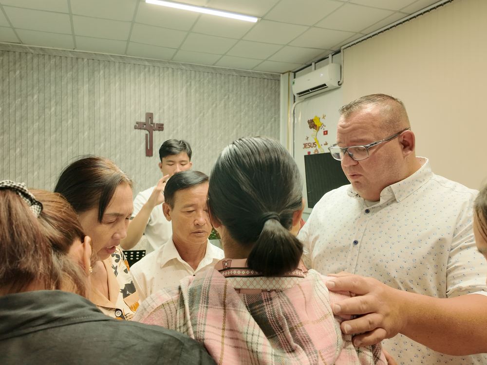 Dr. Shaun praying for church members after the service