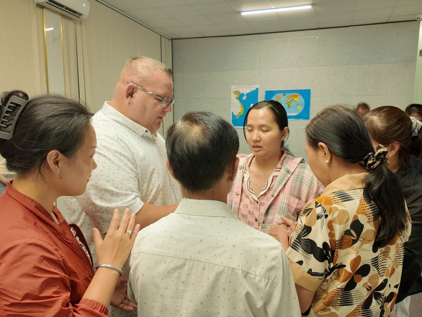 Dr. Shaun praying with a family at the church inside a medical center