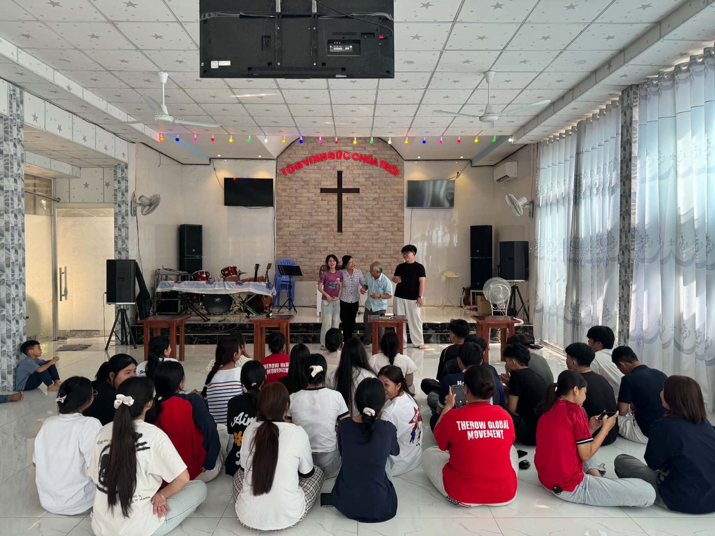 Young adults seated on the floor of Pastor Hieu’s church for the seminar