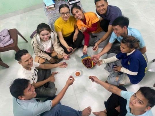 Pastor Quang with members of his church sitting in a circle