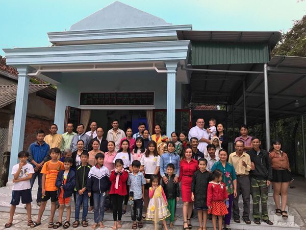 Pastors, church members and children gathered outside a church building in Vietnam