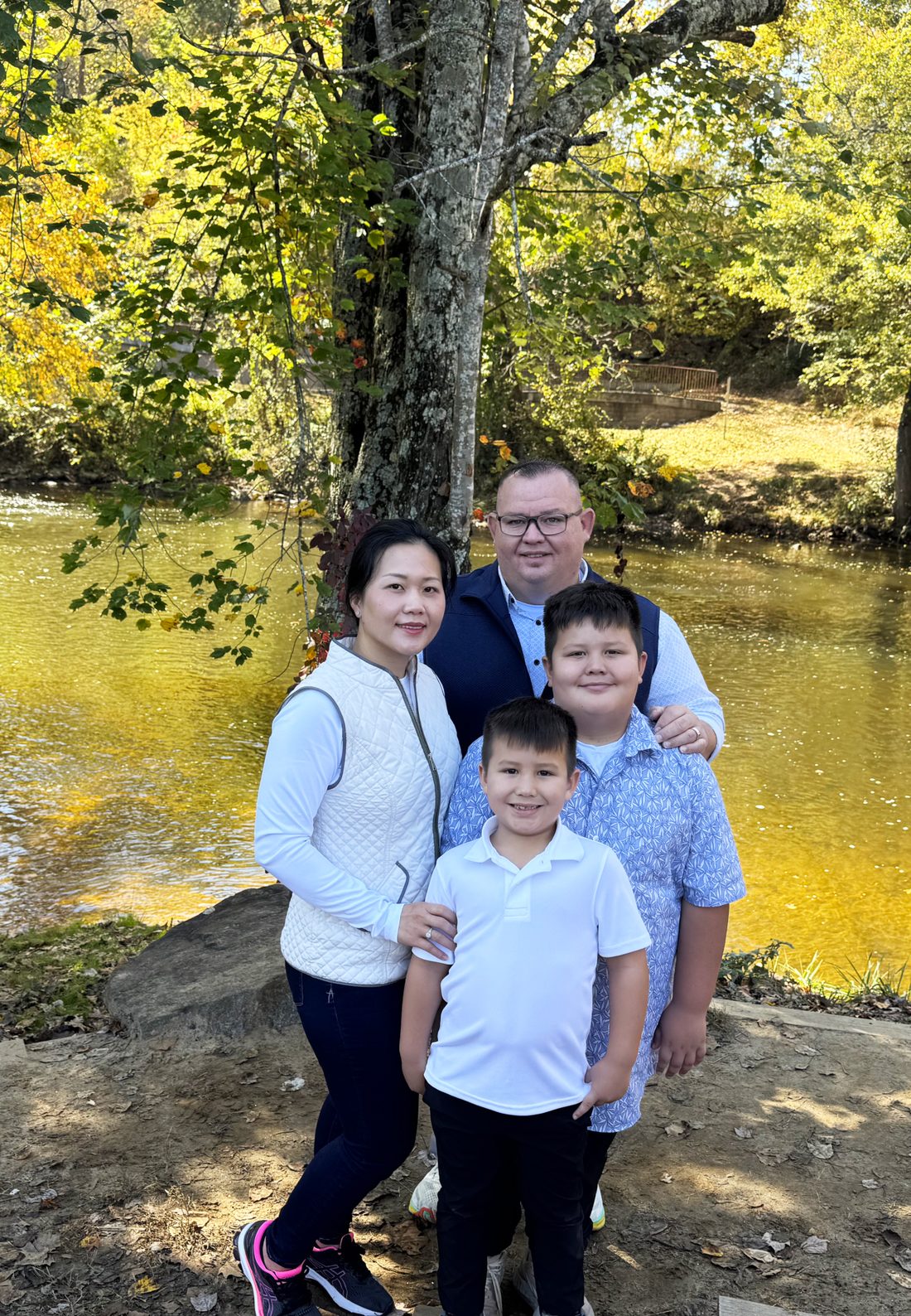 Shaun and Liên Miles with their two sons beside a river