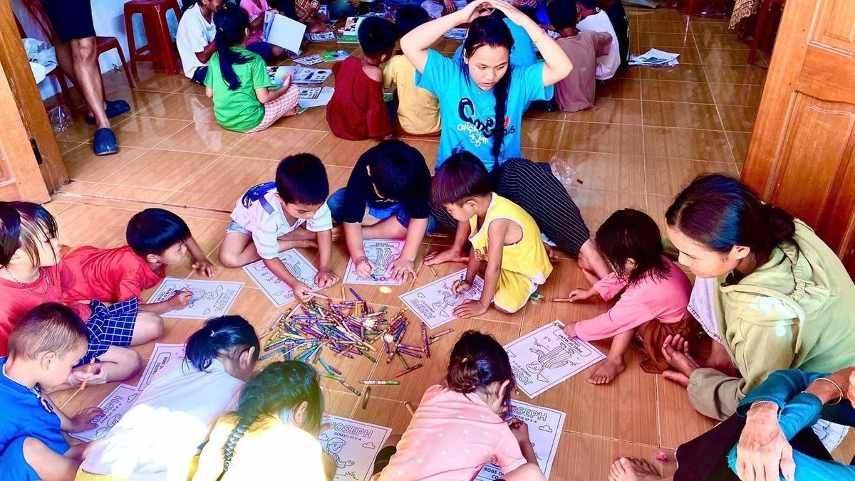 Children coloring Bible story pages about Joseph on the floor at Vacation Bible School