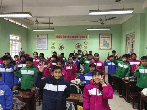 School children in the Highlands wearing new jackets in their classroom