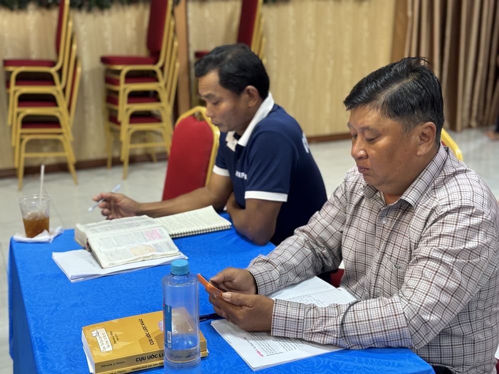 Two pastors studying their Bibles at a table