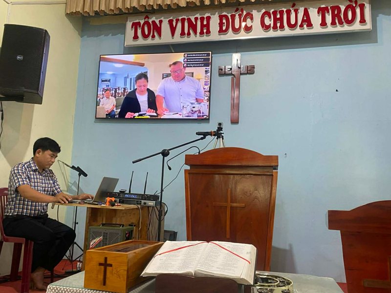 A training session led online, with Dr. Shaun and Liên Miles on the screen at the front of the church