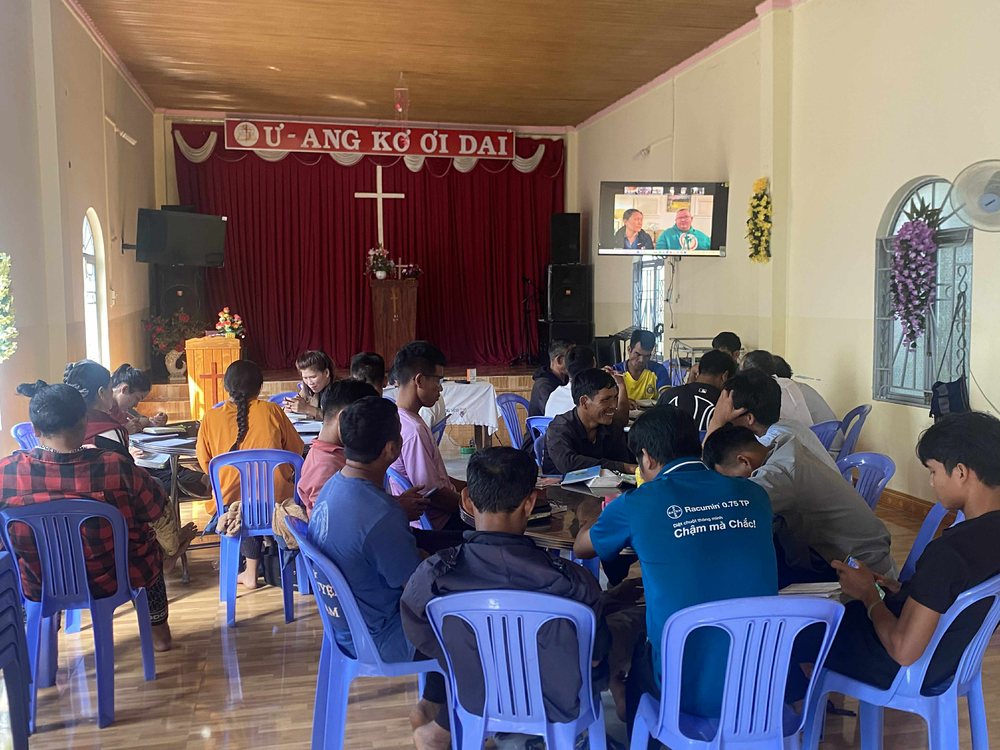 A highlands congregation working in groups during a training session taught by video link